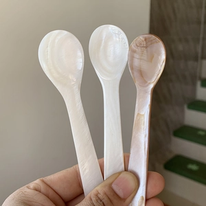Close-up of white and tan mother of pearl shells spoons showing natural glossy texture