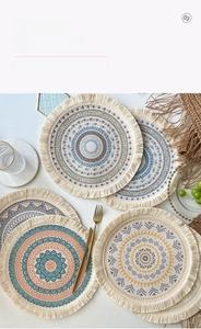 Close-up of bohemian woven coasters with mandala patterns and cotton tassels decoration