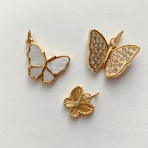 Detailansicht der Schmetterlingsanhänger in Gold, Perlmutt und mit Kristallbesatz