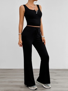Detailed shot of black V-neck sleeveless crop top with buttons and flare pants set