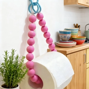 Pink beaded paper towel holder with blue hooks in a modern kitchen setting