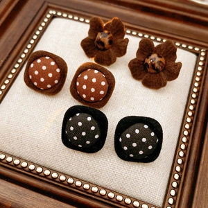 Detailed view of assorted fabric-wrapped button earrings in leopard and polka dot patterns