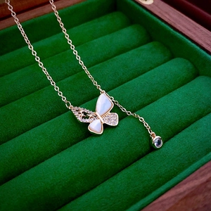 Detail of gold plated butterfly necklace with pearl inlay and crystals in a velvet box