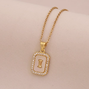 Gros plan du pendentif lettre I en or 18K avec nacre blanche et zircons brillants