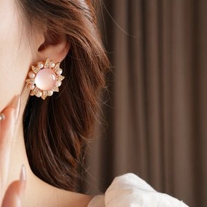 Détail d'une boucle d'oreille vintage fleurie avec pierre rose, perles et diamants