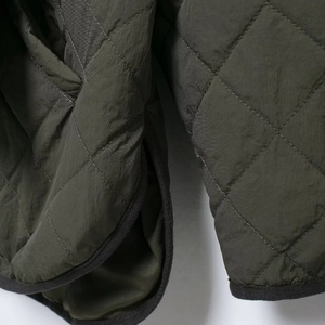 Women's dark green quilted jacket with diamond patterns and scarf collar detail
