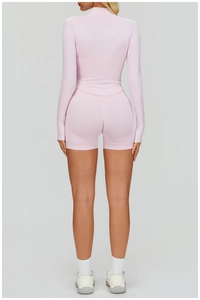Vue arrière d'un ensemble de yoga rose sans couture avec short et haut à manches longues