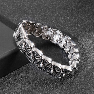 Macro shot of vintage silver skull and cross relief details on a chunky steel bracelet