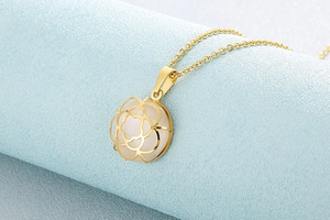 Nahaufnahme der goldenen Libellenkette mit weißem Opal-Edelstein und Blumendetail
