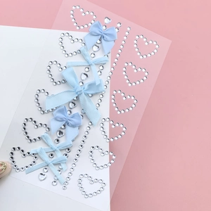 Detail of heart-shaped rhinestone stickers and blue fabric bows for facial makeup decoration