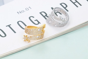 Irregular twisted open ring with star motif and pavé cubic zirconia in gold and silver