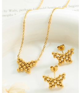 Detail shot of golden beaded butterfly jewelry set with matching necklace and stud earrings