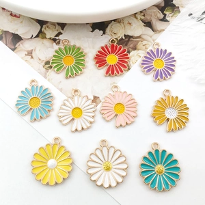 Macro view of colorful alloy daisy flower charms with gold trim and pearl detail