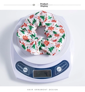 Close-up of Christmas satin hair scrunchie with snowflake prints weighing 4.7g on a scale