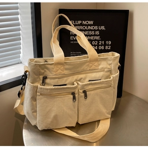 Detailed view of off-white corduroy shoulder bag with multi-pocket design and soft texture