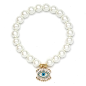 Detailed macro of white pearl bracelet featuring a gold Evil Eye charm with blue inlay