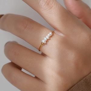 Anello minimalista in acciaio al titanio dorato con cinque perle barocche al dito
