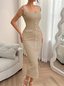 Détail du tissu tissé beige et des boutons argentés sur une robe longue sans manches