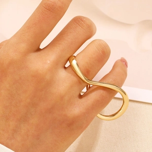 Primo piano di un anello a doppio dito dorato con design geometrico a onda infinity