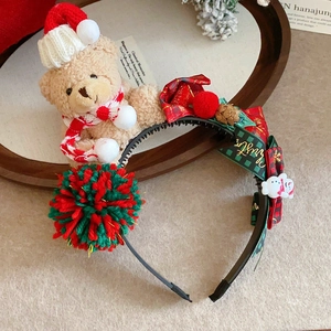 Detail shot of a brown plush bear and colorful pom-poms on a Christmas headband