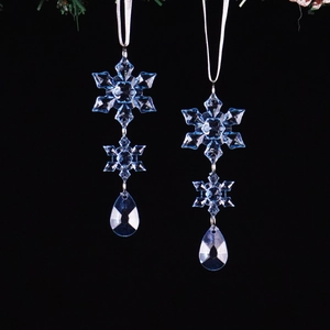 Macro view of blue acrylic snowflake ornaments with glossy teardrop crystal pendants
