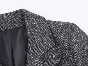 Close-up of black and white herringbone tweed fabric texture on a blazer collar