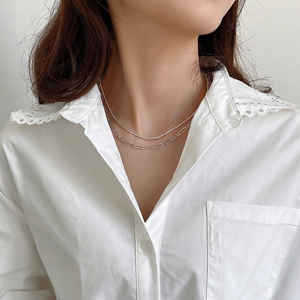 Double-layered 925 sterling silver chain necklace worn by a model in a white shirt