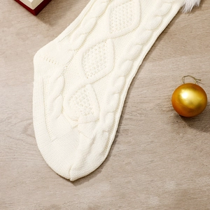 Gros plan d'une chaussette de Noël en tricot blanc avec bordure en fausse fourrure