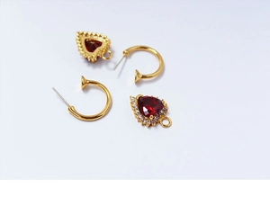 Detail von Vintage-Herzohrringen mit Rubin, Goldhaken und funkelnden Zirkonia-Akzenten