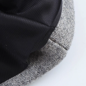 Detailed close-up of grey woven fabric texture and black twill satin lining of the coat