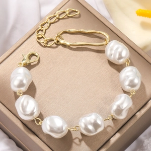 Macro shot of baroque freshwater pearls on a golden chain with lobster clasp detail