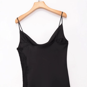 Elegante vestido lencero de satén negro con encaje en una percha de madera