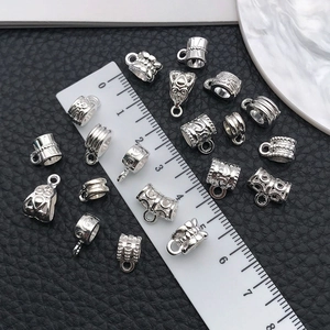 Macro shot of silver alloy DIY jewelry connectors on black leather with measuring ruler