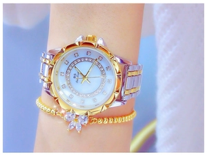 Close-up of gold and silver women's watch with crystal-encrusted dial and floral bracelet