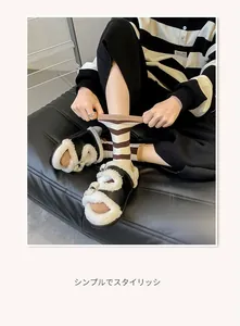 Close-up of brown and white striped crew socks paired with plush slippers and metal buckle