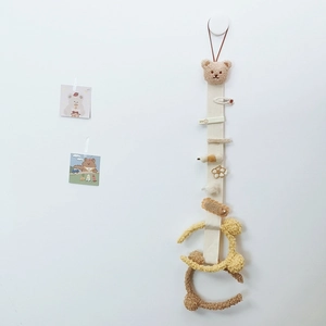 Detail of beige hanging hair accessory organizer with brown bear and colorful clips