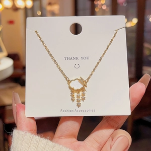 Detail view of gold lightning cloud necklace with pearl inlay and zircon tassels