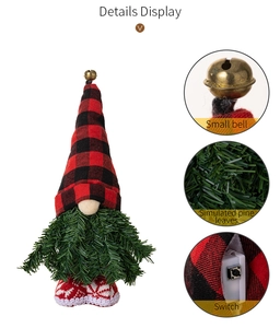 Vista dettagliata della bambola gnomo di Natale con cappello a quadri e barba di pino verde.