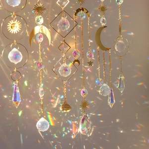 Golden celestial suncatcher wind chime set with crystal prisms casting rainbow reflections