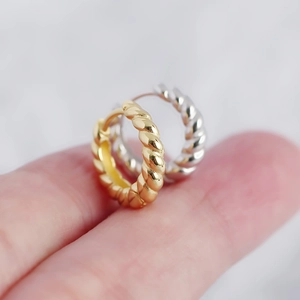 Macro shot of gold and silver twisted rope hoop earrings with high metal texture details