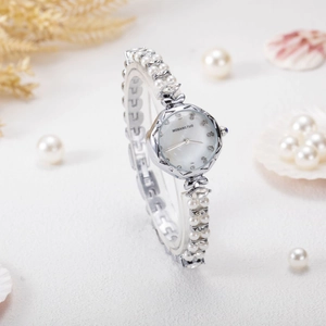Detailed macro view of white mother-of-pearl dial and pearl bracelet with crystal accents