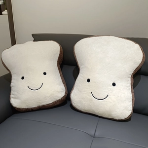 Soft cartoon toast plush pillows with cute smiles on a modern grey sofa