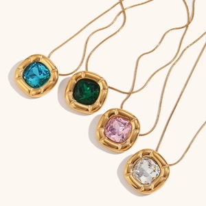 Detail of four colorful square zircon pendants on gold snake chains with radial textures