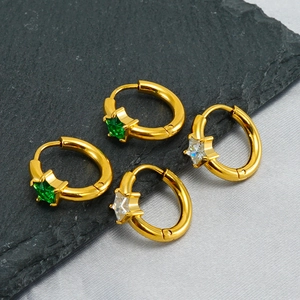 Close-up of gold-plated star hoop earrings with green and white cubic zirconia accents