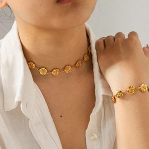 Ensemble collier et bracelet rose élégant en acier inoxydable plaqué or 18 carats sur mannequin