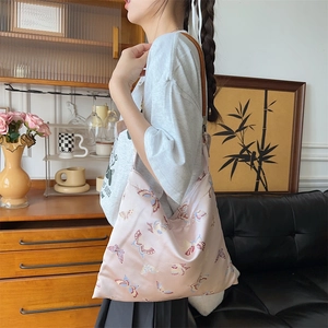 Detail of vintage pink satin tote bag with embroidered butterflies and brown shoulder strap