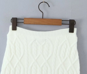 Detail view of white cable knit texture on a sweater skirt set with ribbed elastic waist