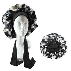 Detail of satin sleep cap with black and white abstract print and wide elastic band