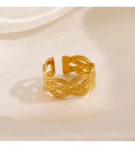 Gros plan d'une bague en acier plaqué or 18k avec texture tressée sur satin beige souple
