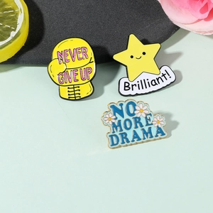 Detailed view of colorful enamel pins featuring Never Give Up and Brilliant! slogans